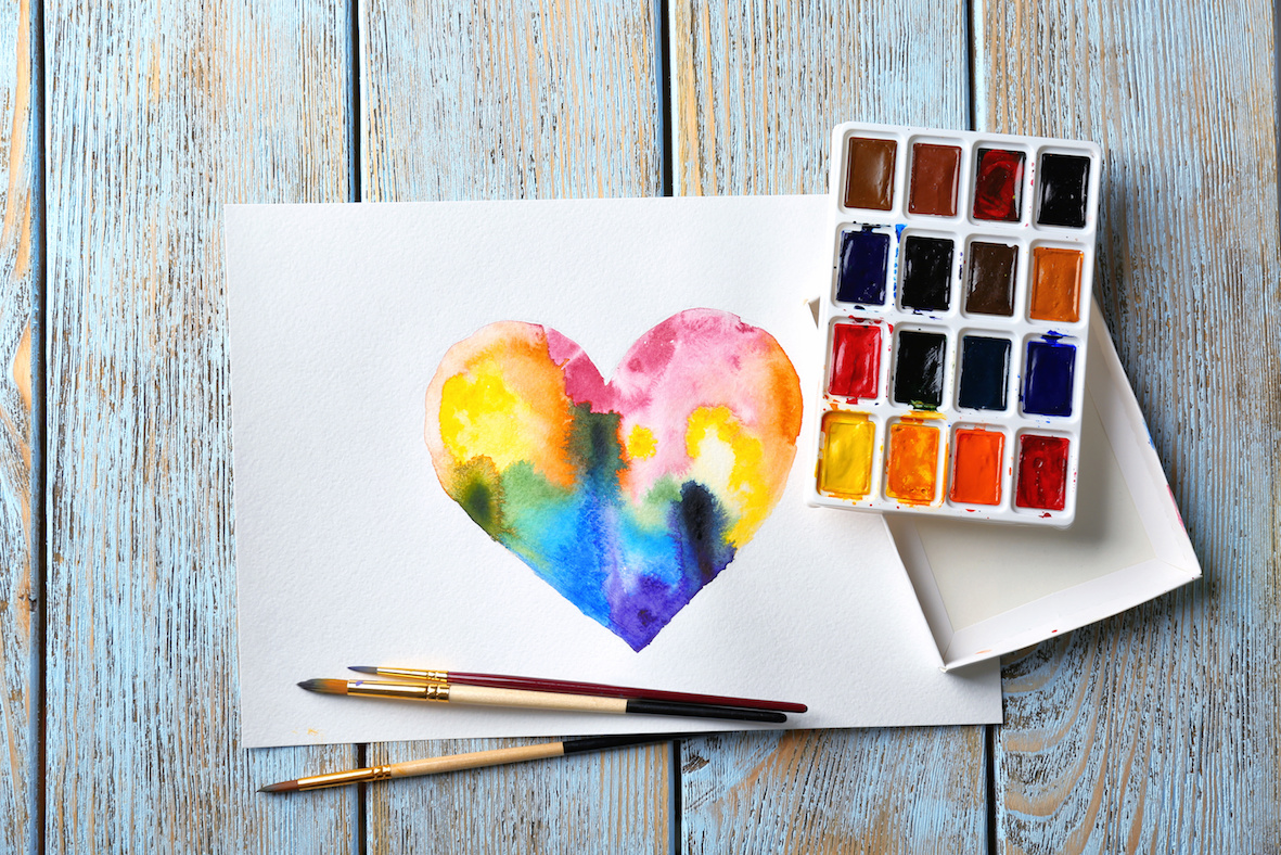 Painting of rainbow heart on wooden background